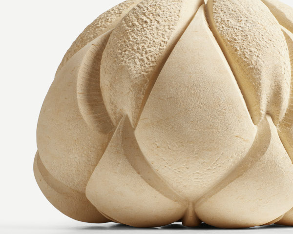 Sculpture by Amanda Randall. Title ‘Bulb.’ Hand carved limestone 35x35x25cm. The image shows an abstract sculpture carved from honey coloured stone. The shape is organic, with approximate rotational symmetry, featuring lobes which resemble a plant or vegetable form.