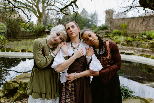 3 women in a line, linking arms.